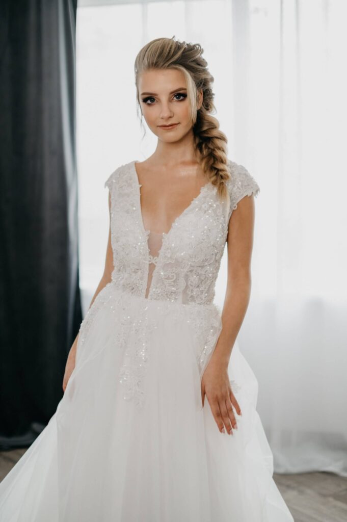 Suknia ślubna De Mariage - przód; dekolt V, kwiatowa koronka z subtelnymi cekinami, rozłożysta tiulowa spódnica